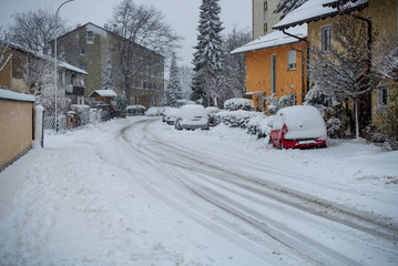 Snow covered street with cars buried in snow