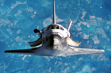 Spaceship on the flight. Space shuttle close-up. Flying rocket. View of the planet Earth  from...