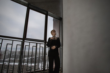 Girl with short hair stays on balcony and smokes