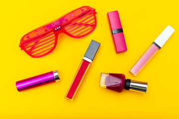 Pink cosmetics on yellow background. Flat lay
