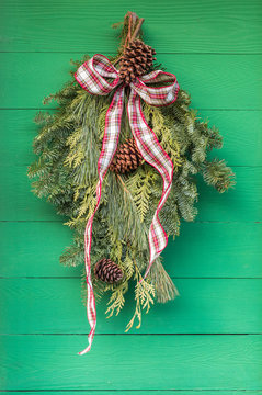 Traditional Evergreen Swag Hung Outdoors On Wood Plank Wall.