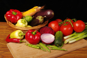 A variety of delicious vegetables on the kitchen board. On black