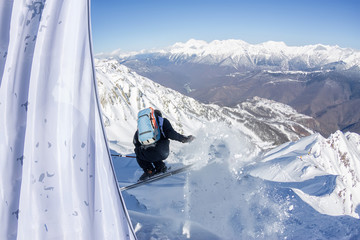 Freerider skier jumping from a slope down in the mountains of the Caucasus, Krasnaya Polyana, Sochi