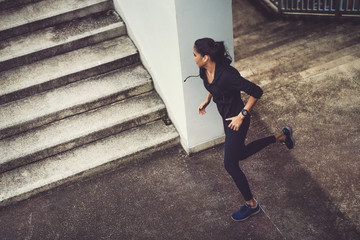 Fitness woman she is running up the stairs.