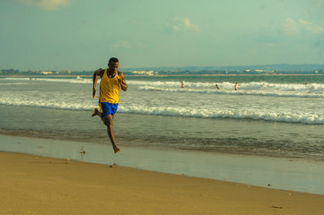 young attractive fit athletic and strong black African American man running at the beach training...