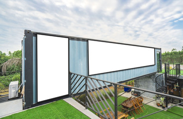 Modern metal building made from shipping house containers and blue sky background .empty white billboard .Blank space for text and images.