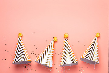 Birthday holiday party concept. Striped golden cones hats and confetti