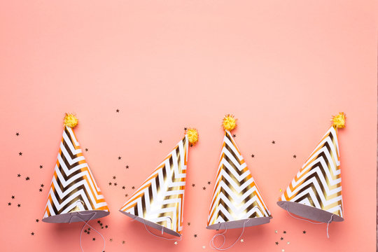 Birthday holiday party concept. Striped golden cones hats and confetti
