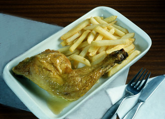 Plato con un cuarto de pollo al grill y patatas fritas.