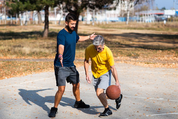 Father and son playing basketball in the park
