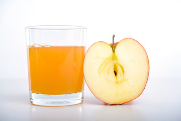 half apple with glass of naturally cloudy juice
