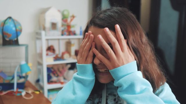 peek a boo. little girl covered her eyes face with her hands hide-and-seek waiting for a surprise. slow motion video. teen girl playing bo-peep. lifestyle childhood concept game hy - spy