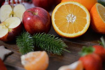 Different kind of fruits on wooden background, oranges, strawberries, mandarins, clementines, apples. Healthy organic eating and dieting concept. Winter assortment
