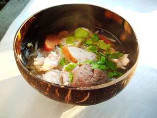 Thai street food. Noodles serve in a coconut shell instead of bowl. Street food asia