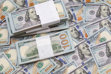 One hundred dollar bills on the table as background