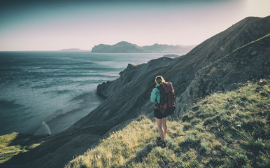 Fototapeta premium Girl hiker on a the edge above the sea
