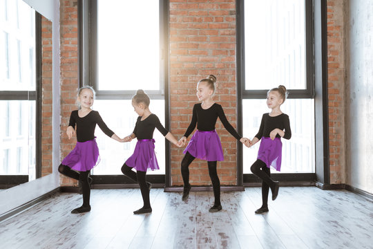 Cute little kids dancers on dance studio. Choreographed dance by a group of small ballerinas practicing at a modern ballet school