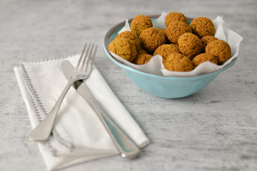 Baked chickpea falafel balls on blue plate on grey background , healthy and vegan food with tahini deep and hot pepper , traditional Mediterranean , top view , flat lay with copy space  