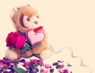  Teddy bear holding a rose and heart.The concept of Valentine's Day