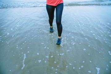 Woman jogging workout on the beach in the morning. Relax with the sea walk. in summer