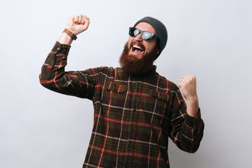 Fototapeta premium Happy bearded man celebrating victory, gesturing with fists up
