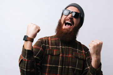 Naklejka premium Screaming bearded man celebrate his winn, gesturing with fists up