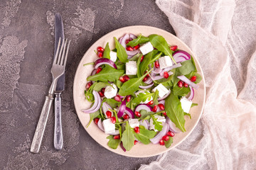 Healthy salad with spinach, arugula, red onion and pomegranate