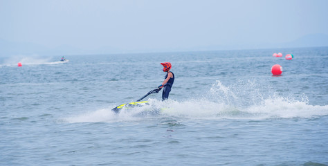 Young guy riding on the jet ski in gulf of Siam