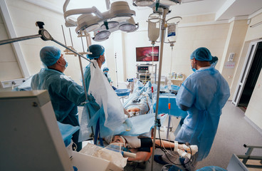 Fototapeta na wymiar Process of gynecological surgery operation using laparoscopic equipment. Group of surgeons in operating room with surgery equipment