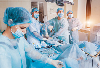 Process of gynecological surgery operation using laparoscopic equipment. Group of surgeons in...