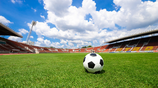 soccer ball on soccer field green grass , football field  athletics stadium and blue sky background