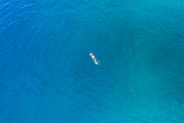 Aerial drone view of a snorkeler over a tropical coral reef