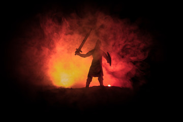 Medieval battle scene. Silhouettes of figures as separate objects, fight between warriors on dark toned foggy background. Night scene.