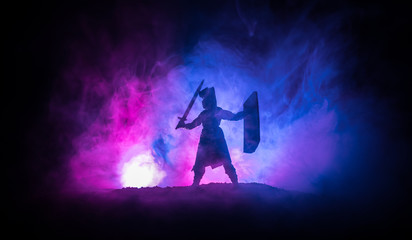Medieval battle scene. Silhouettes of figures as separate objects, fight between warriors on dark toned foggy background. Night scene.