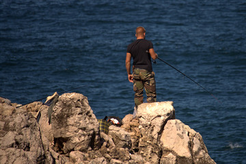 Fototapeta na wymiar fisherman on a rock