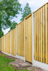 New wooden fence construction in backyard