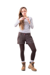 Fototapeta premium Relaxed blonde long hair hipster beauty rolling cigarettes. Full body isolated on white background. 