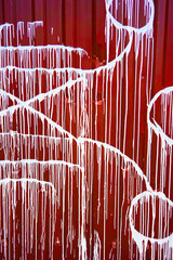abstract drawing of white paint on a red wall