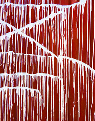 abstract drawing of white paint on a red wall