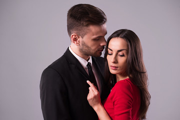 Love you so much! Beautiful stylish and elegant couple in suit and dress are hugging, have a fun and posing isolated in studio. Holidays and events. St Valentine's day. Day of lovers