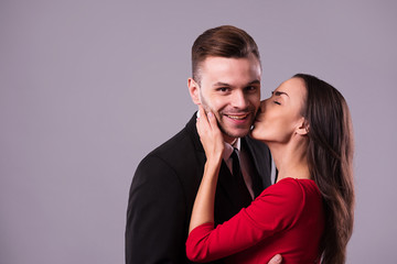 Love you so much! Beautiful stylish and elegant couple in suit and dress are hugging, have a fun and posing isolated in studio. Holidays and events. St Valentine's day. Day of lovers