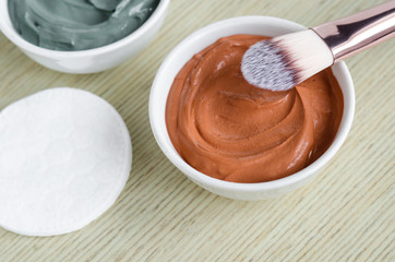Small white bowl with red cosmetic clay mask. Homemade beauty treatments. Copy space.