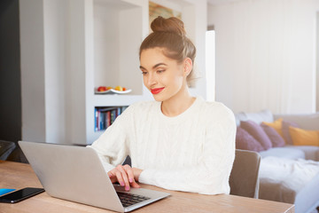 Young woman using laptop while working from home