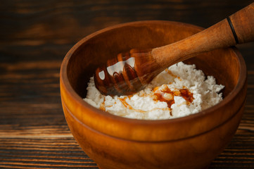 Cottage cheese with honey in a wooden bowl. Close-up