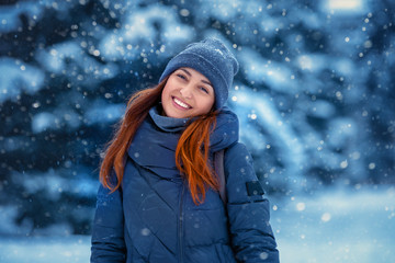 Portrait of a beautiful young cheerful woman in winter in nature