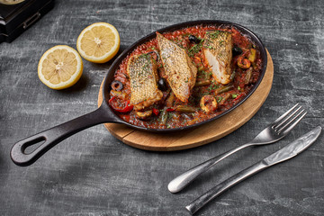 Stewed perch in tomato sauce, serve food in the Provencal style, in a pan. top view , copy Space.