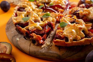 Sliced Delicious fruits pie with plums close-up