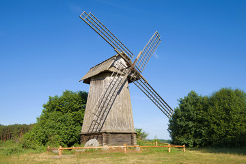 Fototapeta na wymiar Old wooden windmill close-up on a sunny June afternoon. Mikhaylovskoye, Pskov region