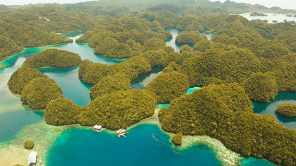 Aerial view: Bucas Grande Island, Sohoton Cove. Philippines. Tropical sea bay and lagoon, beach. Tropical landscape hill, clouds and mountains rocks with rainforest. Azure water of lagoon. Shore