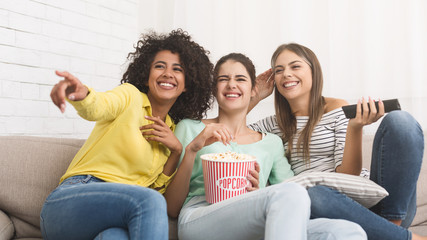 Female friends watching film and eating popcorn